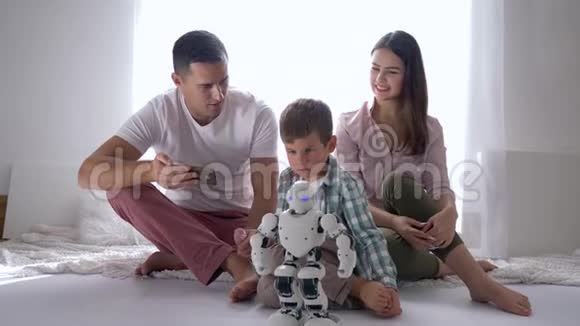人工智能幸福家庭玩机器人遥控手机坐在地上视频的预览图