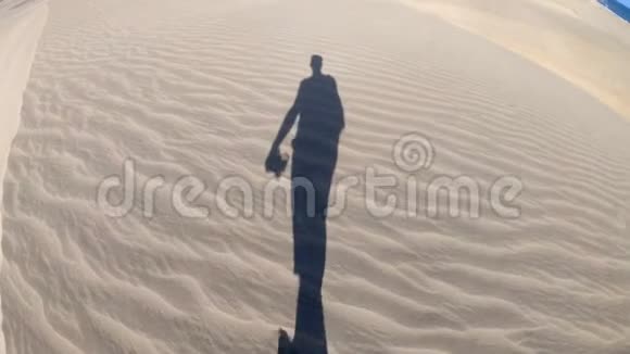 沙漠中一个孤独的徒步旅行者穿过沙丘视频的预览图