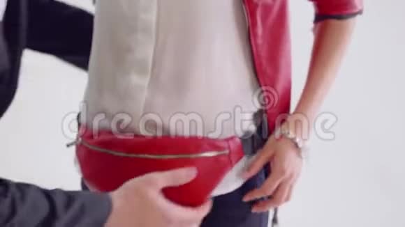 男人把红色的扇子包放在模特臀部视频的预览图