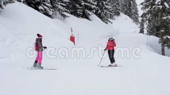 滑雪者站在斜坡上互相展示滑雪路线视频的预览图
