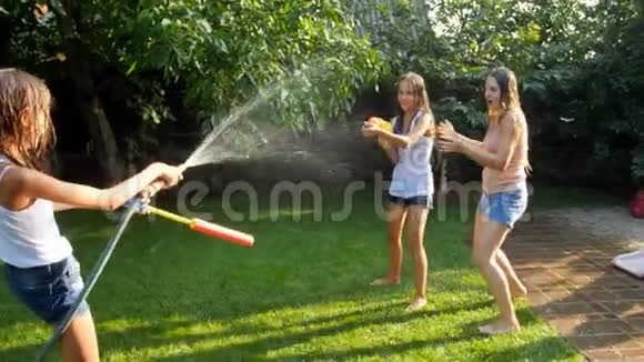 4k视频少女在后院给母亲和姐姐用花园水管喷水视频的预览图