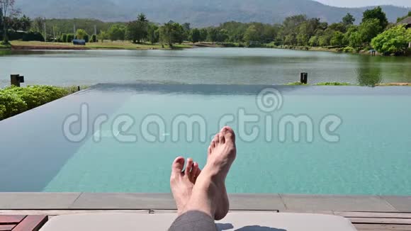 K4光着脚躺在游泳池边的躺椅上晒太阳视频的预览图
