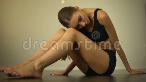 坐在地板上的瘦女孩心烦意乱患有营养不良恶心视频的预览图