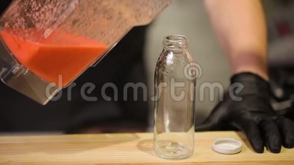 在餐厅酒吧柜台将橙色冰沙倒入瓶子中视频的预览图
