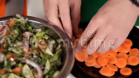 女孩把胡萝卜放进沙拉里在家做饭视频的预览图