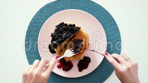 女人吃浆果薄煎饼刀叉顶景早上早餐视频的预览图