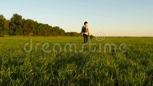 妈妈和宝宝正慢慢地沿着绿色的草坪走着视频的预览图