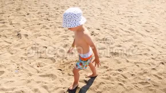 4k视频小赤脚幼儿在阳光明媚的日子在沙滩上感受热沙视频的预览图