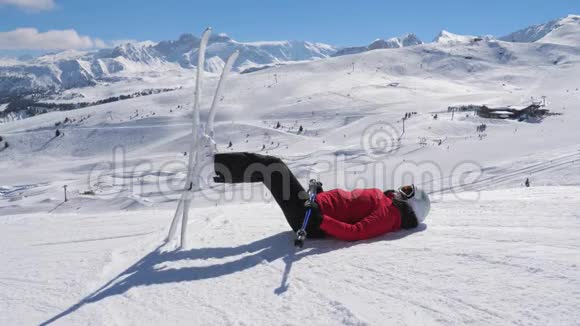 滑雪者躺在雪地上用滑雪板支撑着腿视频的预览图