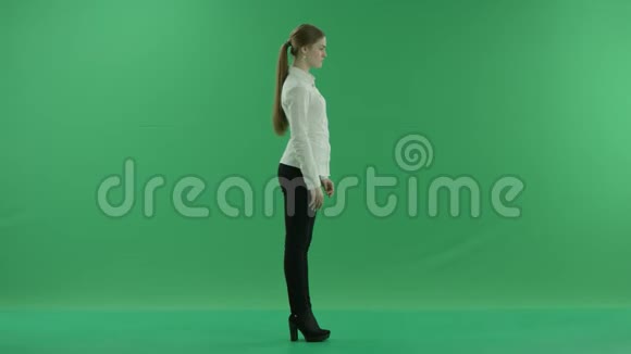 在绿色背景前滚动通过虚拟显示器的商务女性她穿着正装白衬衫视频的预览图