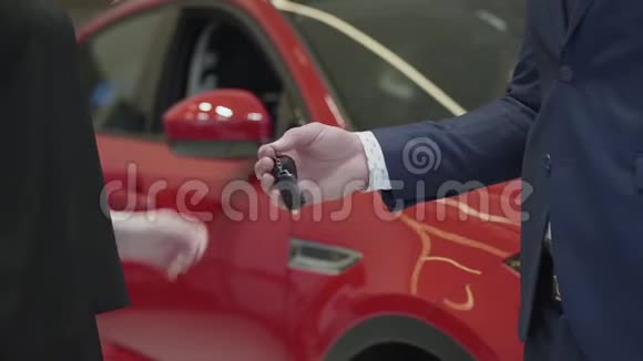 西装革履的未被认出的推销员把车钥匙交给未被认出的女商人然后在车里握手视频的预览图