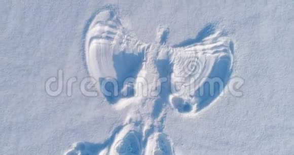 雪天使在白雪覆盖的区域打印空中镜头摄像头渐渐移开视频的预览图