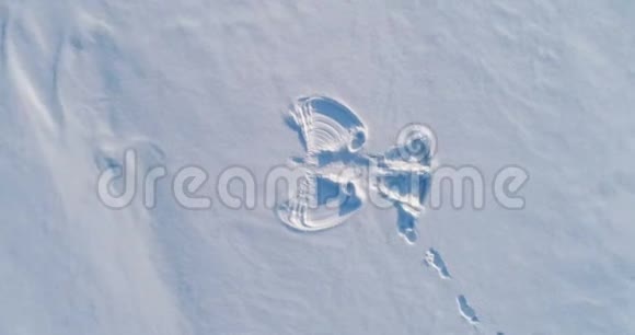 雪天使在白雪覆盖的区域打印空中镜头相机在旋转视频的预览图