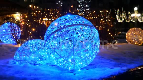 节日照明在圣诞假日的夜间冬季大街上用人造蓝色照明的球视频的预览图