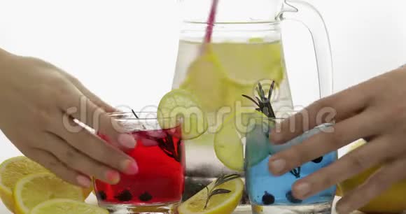 女人和男人的手拿着清爽的苏打红蓝鸡尾酒和柠檬视频的预览图