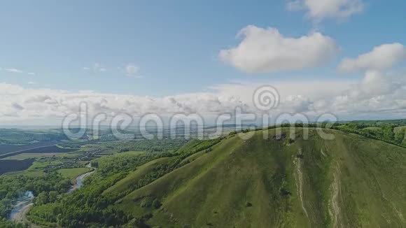 摄像机缓缓地从山上升起俯瞰着美丽的山谷前方是美丽的天空云彩和山视频的预览图