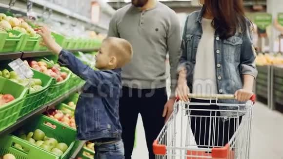 一家人的妈妈爸爸孩子都在超市买水果把菠萝放进购物车说着视频的预览图