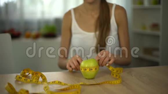 女孩用胶带线测量苹果计算卡路里有机食物和饮食视频的预览图