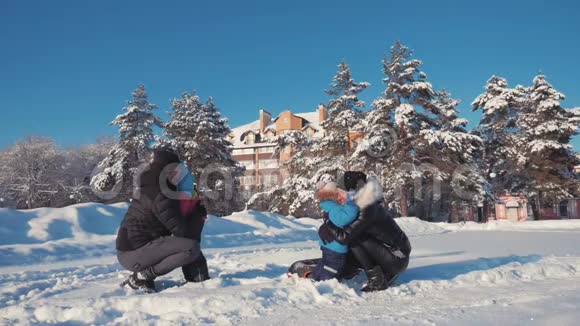 父亲母亲和两个孩子在大自然中玩着雪冬散步在户外快乐的家庭视频的预览图