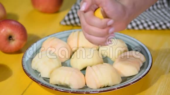 女孩的手把柠檬汁挤在苹果上视频的预览图