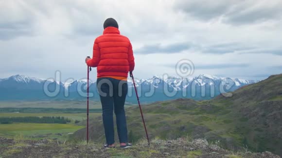 山里的旅行者站在岩石上靠在瑞典的棍子上视频的预览图