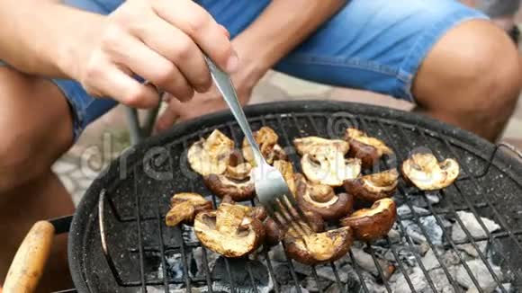 人们把美味的香葱蘑菇翻过来在烤肉时用煤烤视频的预览图