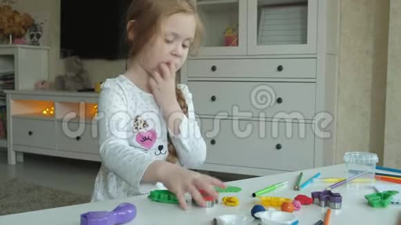 一个小女孩玩塑料线把图形剪成形状图形和彩色铅笔躺在桌面上视频的预览图