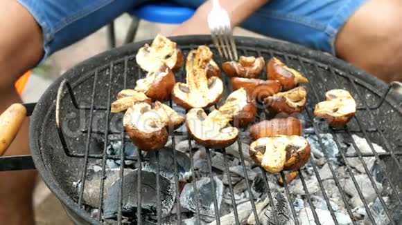 人们把美味的香葱蘑菇翻过来在烤肉时用煤烤视频的预览图