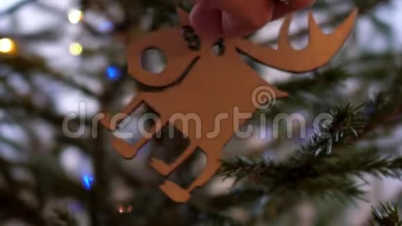 慢动作亲密的女孩手把麋鹿挂在圣诞树上视频的预览图