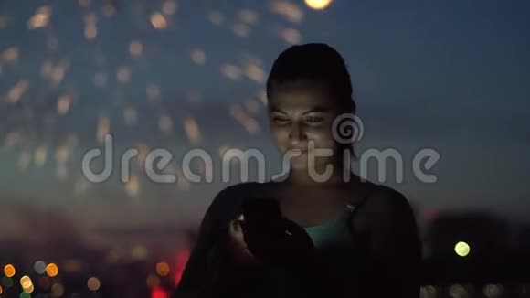 这个女孩在烟花背景上使用了一个萨特电话4K视频的预览图