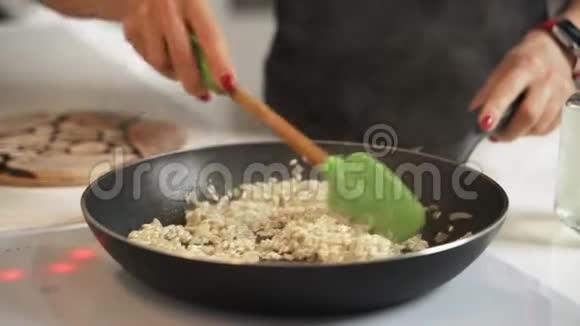 无法辨认的女性烹饪意大利烩饭的中段拍摄视频的预览图
