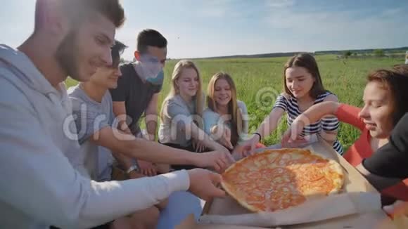 傍晚日落时分孩子们的朋友们在户外挑选披萨视频的预览图