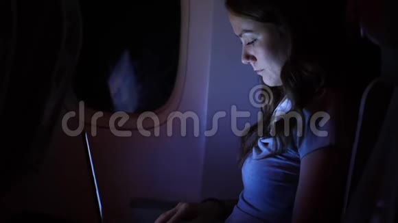 女人在飞机上做笔记本晚上在黑暗的飞机沙龙视频的预览图