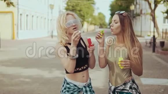 带着太阳镜的时髦女孩喜欢在街上玩泡泡视频的预览图