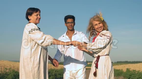 慢动作两个穿着民族服装的女人和一个戴护目镜的印度男人牵着手微笑着站在路上视频的预览图