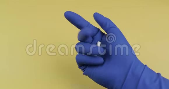 穿着蓝色医用手套的白色药丸女人吃了一片药视频的预览图