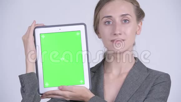 一位年轻的金发女商人展示数码平板电脑视频的预览图