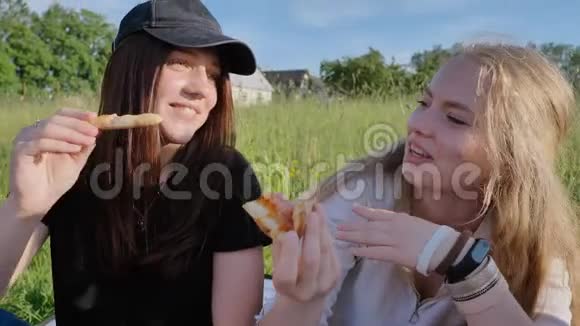 傍晚日落时分两个学童的女朋友在户外吃披萨视频的预览图