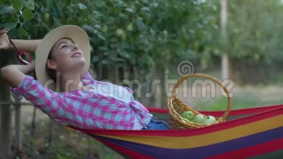 苹果作物农民女孩梦想放松到吊床吃水果从篮子后收获在视频的预览图