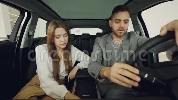 潜在的购车者夫妻两人正坐在前排座位上检查汽车内部视频的预览图