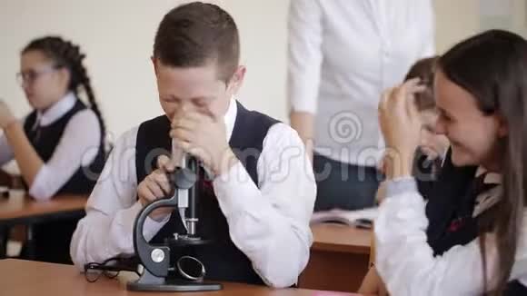 穿校服的学童用显微镜做实验室工作学校教育的理念视频的预览图