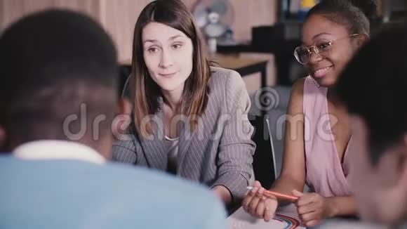 成功的女商务教练激励着多民族的工人在现代轻办公室特写的见面视频的预览图
