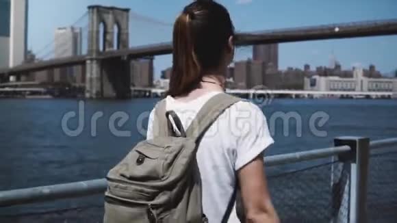 纽约曼哈顿天际线全景照片附近美丽的年轻旅游女子背着背包张开双臂满怀喜悦视频的预览图