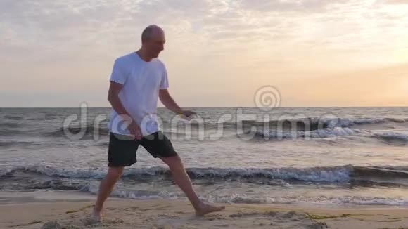 太阳升起的时候一个穿着紧身衣的人在海边伸展着腿视频的预览图