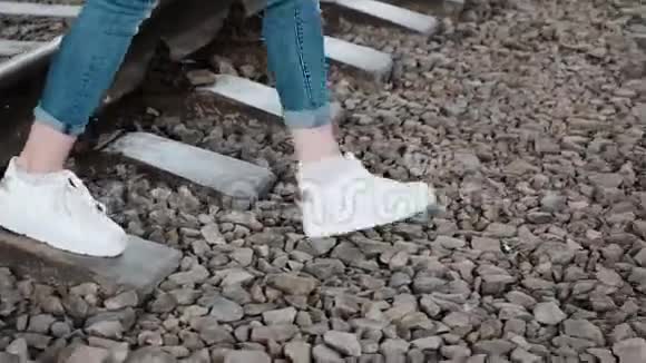 苗条的女人她的腿勇敢地穿过铁路视频的预览图