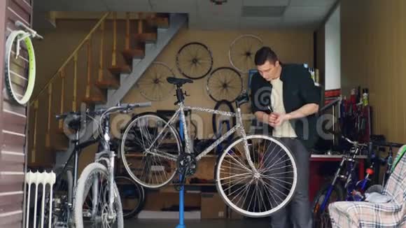 熟练的男性机械师用扳手固定自行车轮然后转动它并检查很多周期备件工具视频的预览图