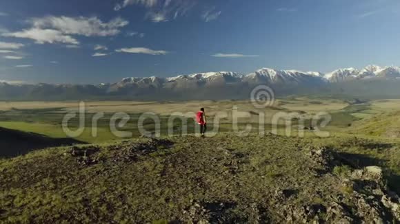 空中近距离女性徒步旅行者自豪地站在山上在夏天站在上面的年轻女子背着一个红色背包视频的预览图