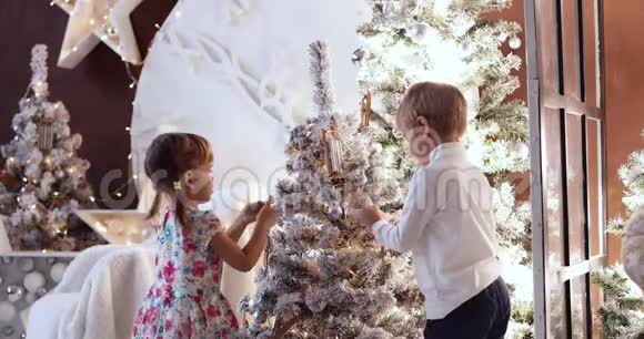 圣诞装饰品家庭时间圣诞树旁边的孩子孩子在家玩圣诞节寒假概念视频的预览图