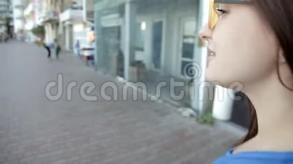 一个年轻的女孩走过位于海边的城市休息散步视频的预览图