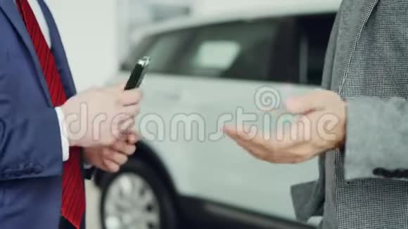 与销售经理成功交易并握手后男性手拿车钥匙的特写镜头购买和购买视频的预览图